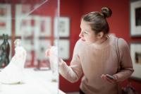 Woman visitor using phone in museum