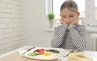 Photo of a girl sitting in front of a plate of food