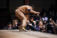 Actor on a thrust stage performing to young people