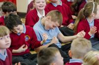 Photo of children in audience playing air guitar