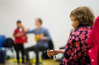 Child playing guitar as part of family music project