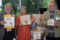 Photo of three people holding books