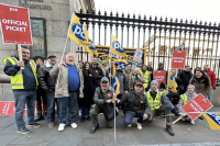 Workers stand outside the British Museum protesting. The photo shows around 30 people, holding signs and banners