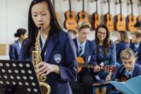 Student playing the saxophone in music lesson.