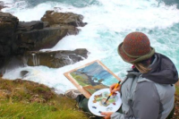 A painter on a cliff overlooking the sea