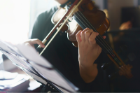 A music stand and close up of a violin player's hands