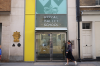 A woman walks past the entrance of the Royal Ballet School in London