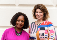 Jennifer Francis and Lucy Littlewood stand in front of a white wall