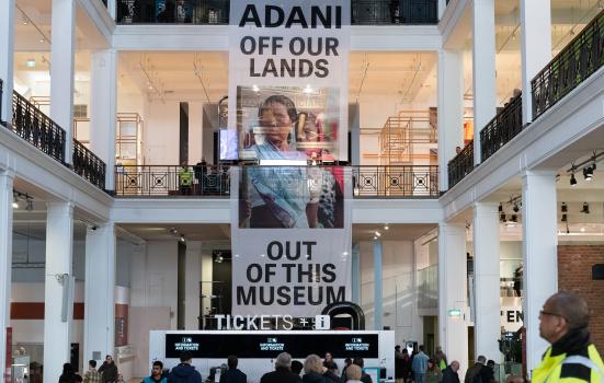 Protesters unfurl a 12-metre banner spanning the full height of the Science Museum's Energy Hall reading ‘Adani off our lands and out of this museum'