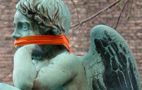 Photo of a cherub statue with cloth tied around its mouth