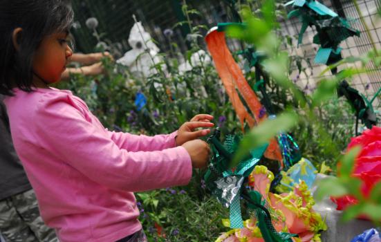 A girl in a garden with coloured paper artwork