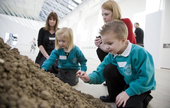 Two school childeren interact with an art piece