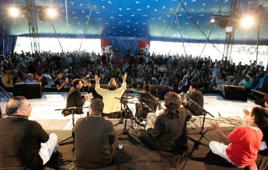 Qawwali group on stage with the audience in the background at London Mela