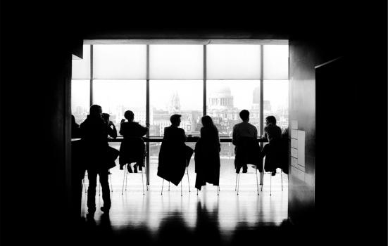 Photo of people sitting in front of a large window