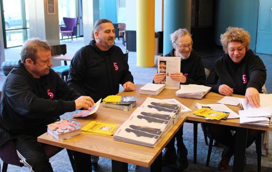 Photo of four people helping pack mailouts