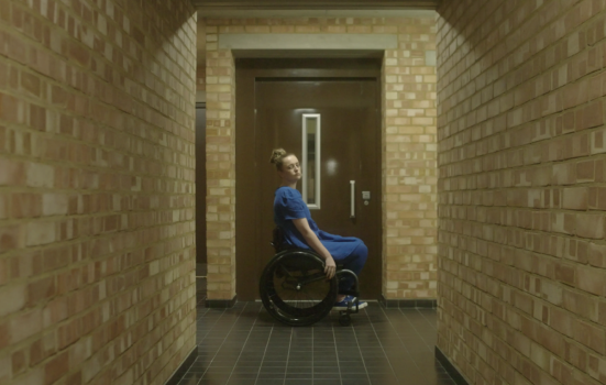 A woman in a wheelchair in a corridor