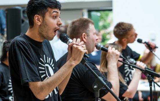 Photo of three young men singing with microphones