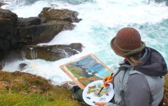 A painter on a cliff overlooking the sea