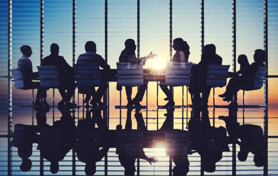 Silhouetted figures at a boardroom table