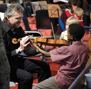 Young boy being tought how to play violin