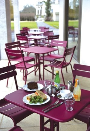 5 SETS OF PINK TABLES WITH 4 CHAIRS EACH AND SOME FOOD ON THEM