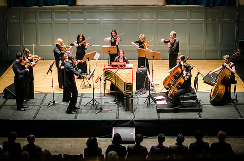 Ensemble of players on stage watched by audience