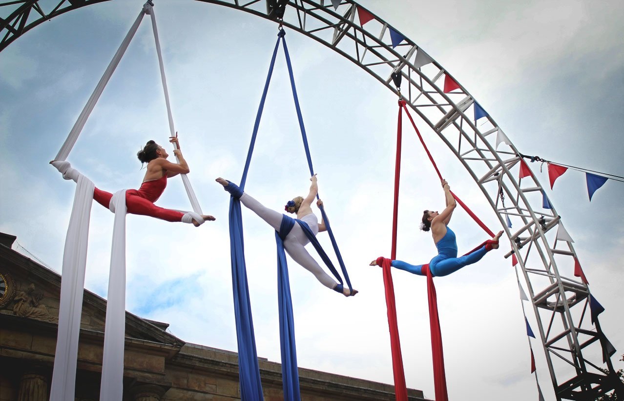 Photo of three aerial silk performers