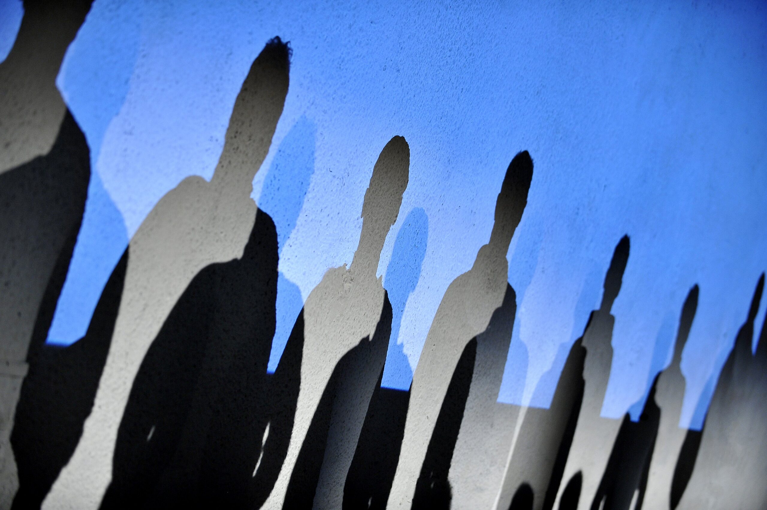 Photo of human shapes against blue sky