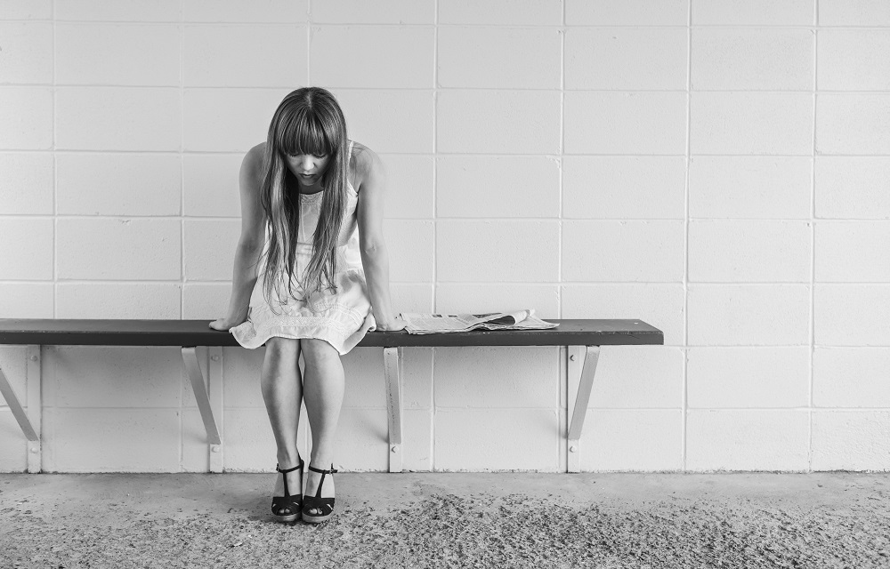 Photo of woman sitting on a bench