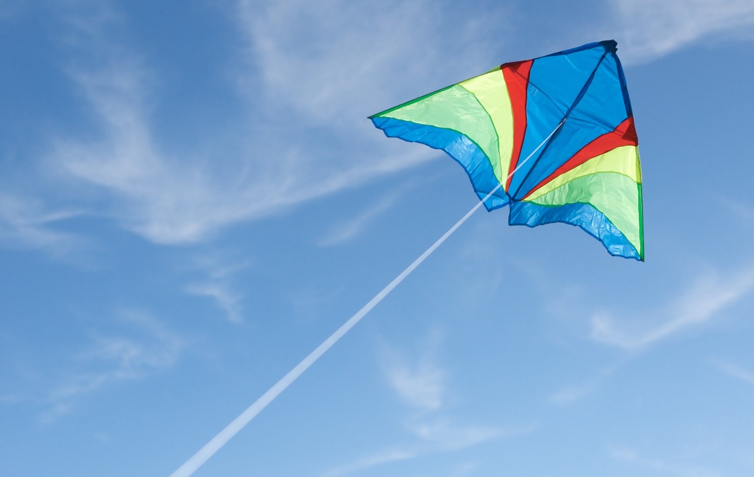 Photo of kite flying against blue sky