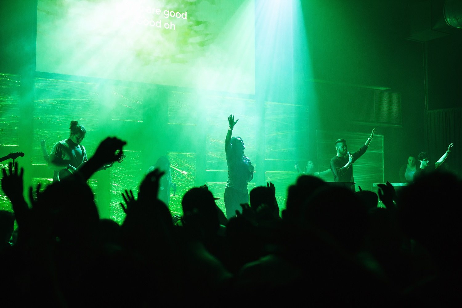 Performers on stage under green light