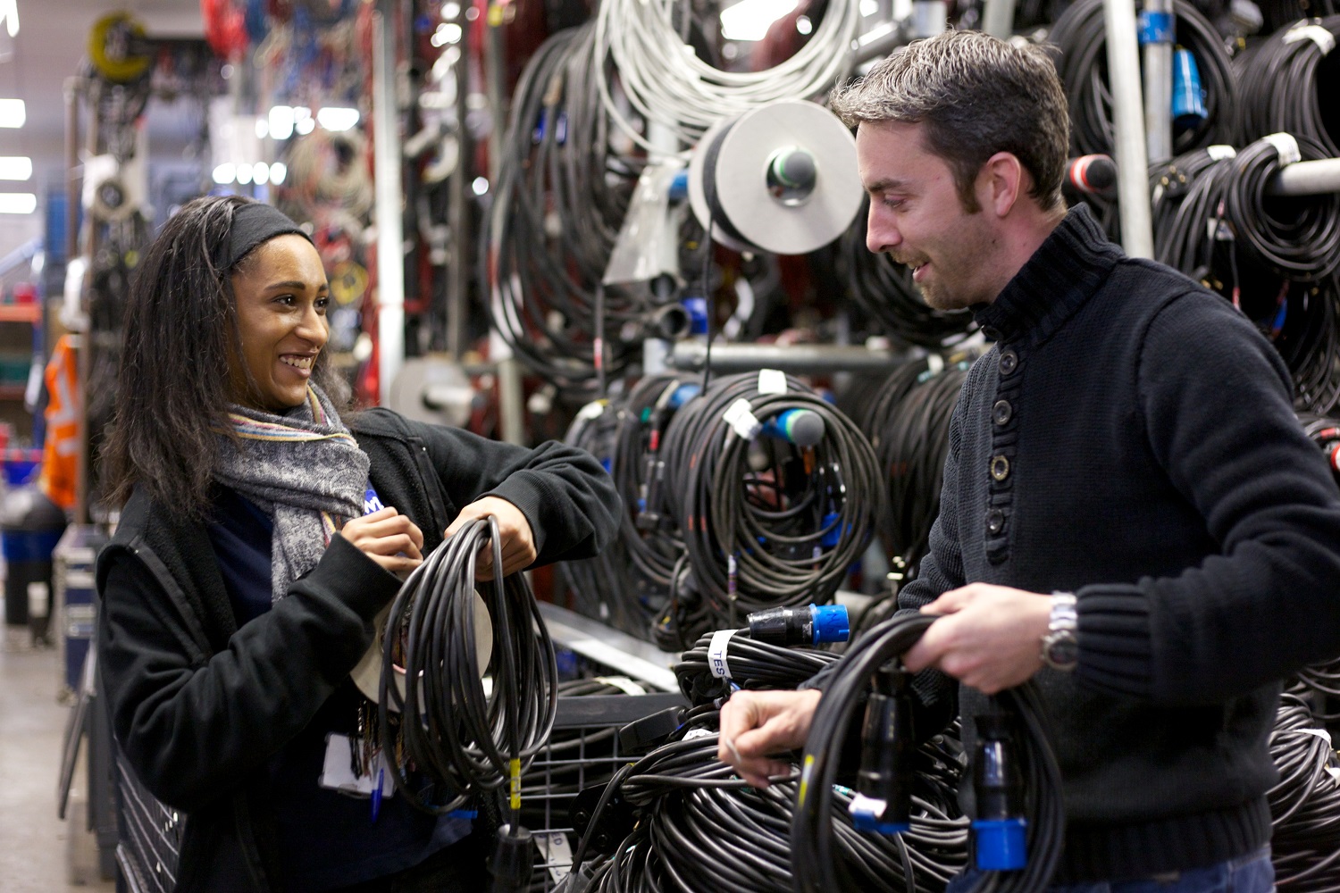 An apprentice holding wires next to a technician