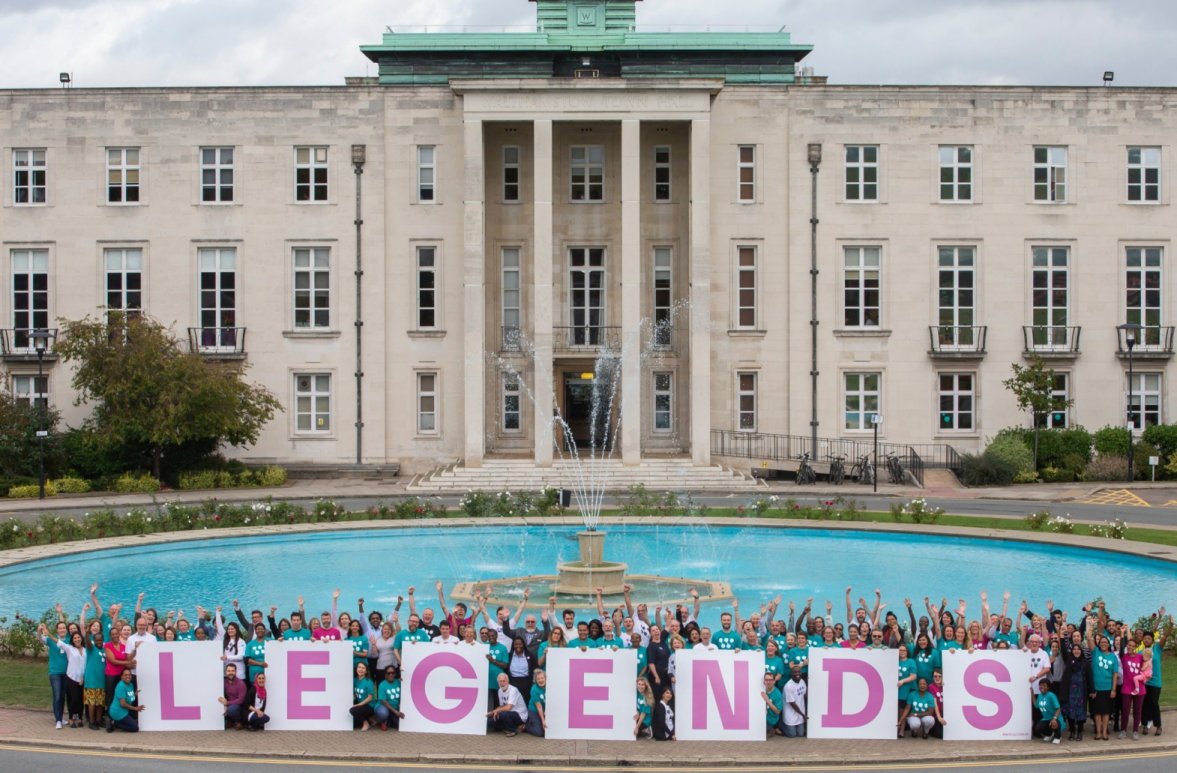 Photo of large building with people holding legends banner