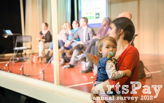 A woman holding a baby in front of a rehearsal