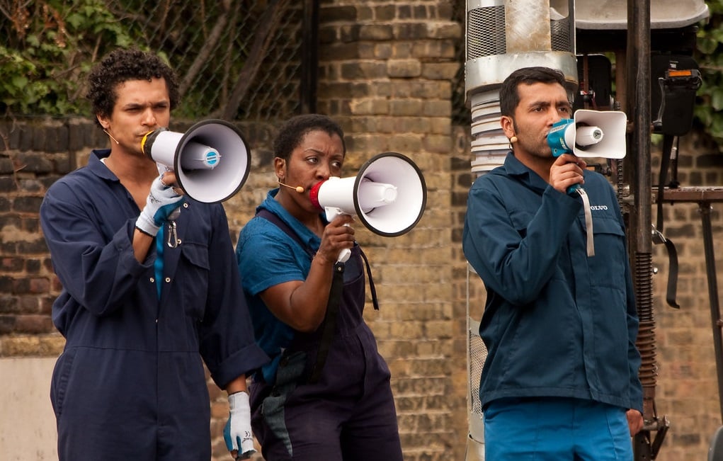 A photo of three people holding megaphones