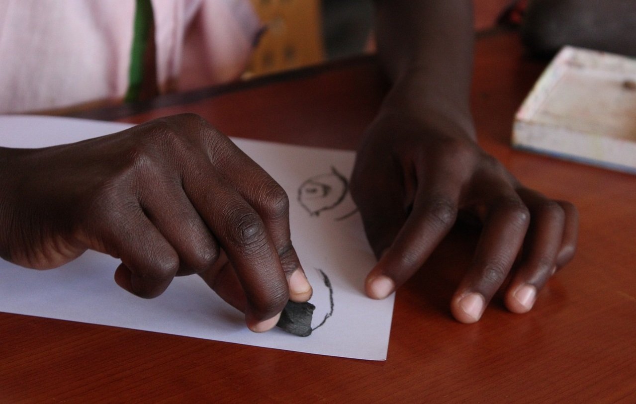 A photo of a young person's hands drawing