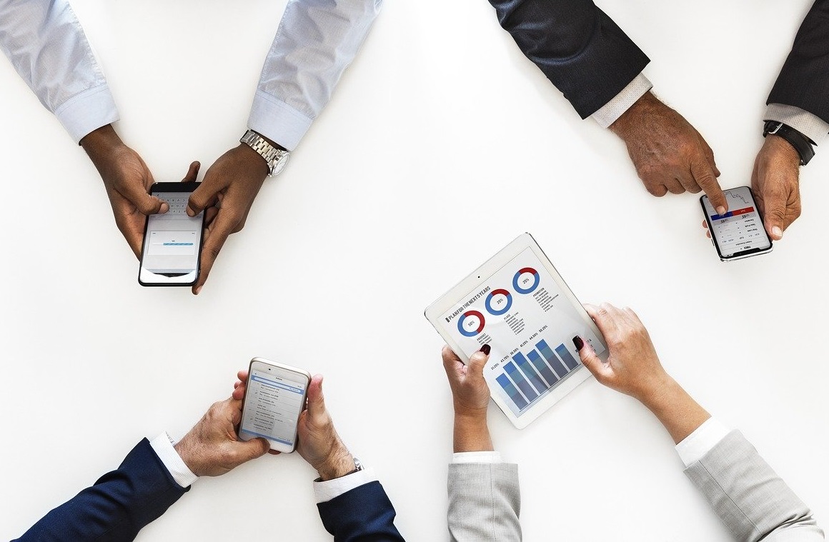 A picture of four people's hands holding mobile devices