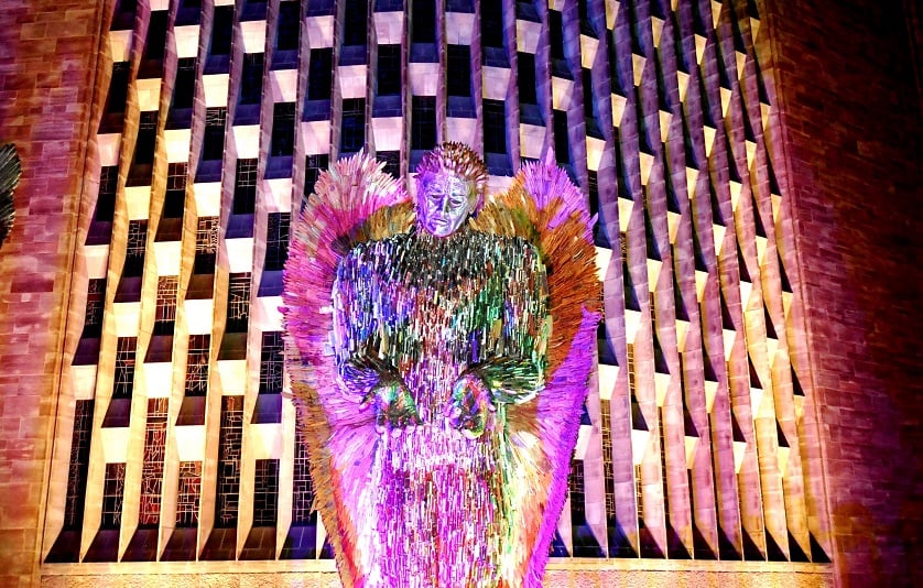 A photo of a brightly-lit sculpture on an outside wall