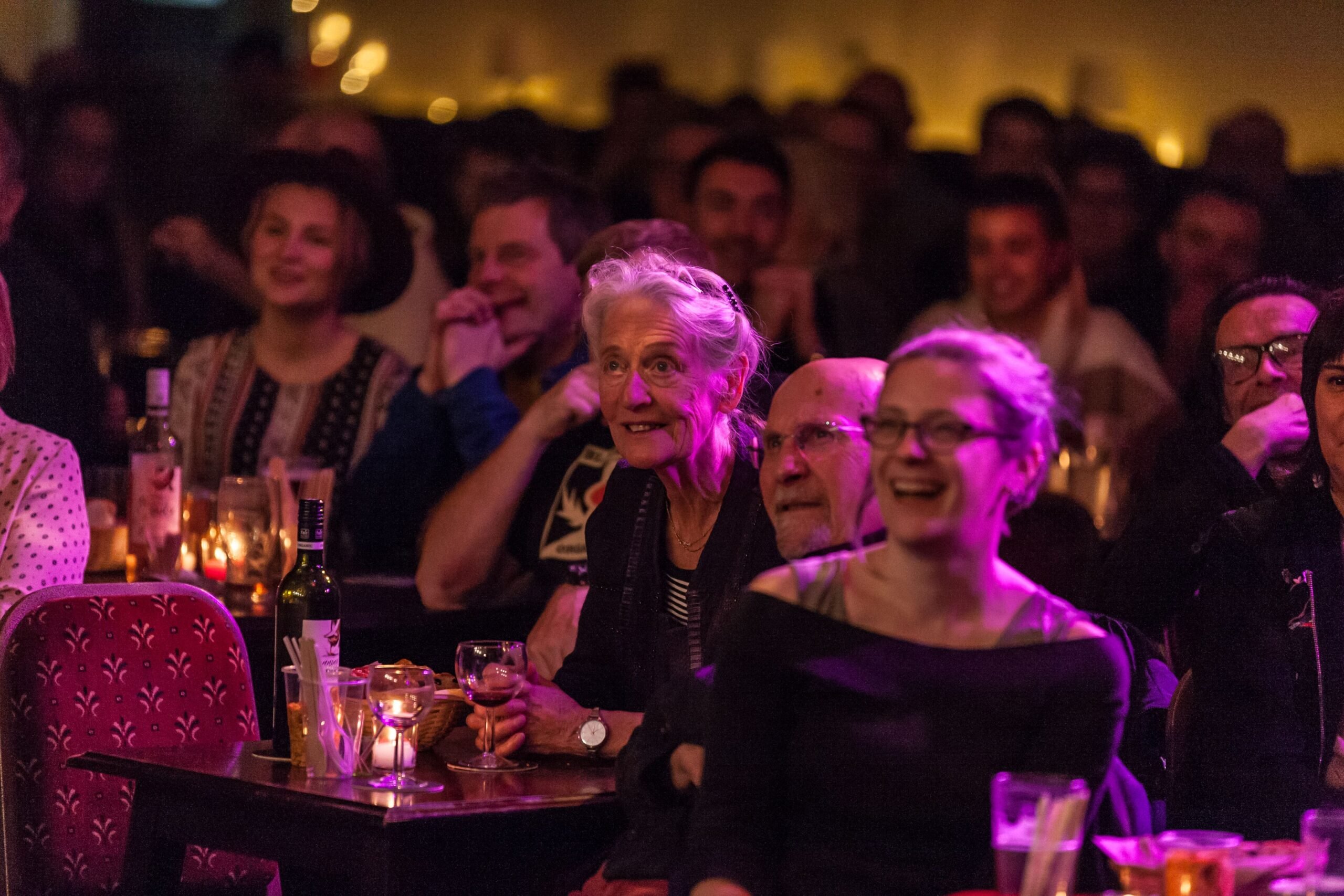 Audience sitting at tables with drinks