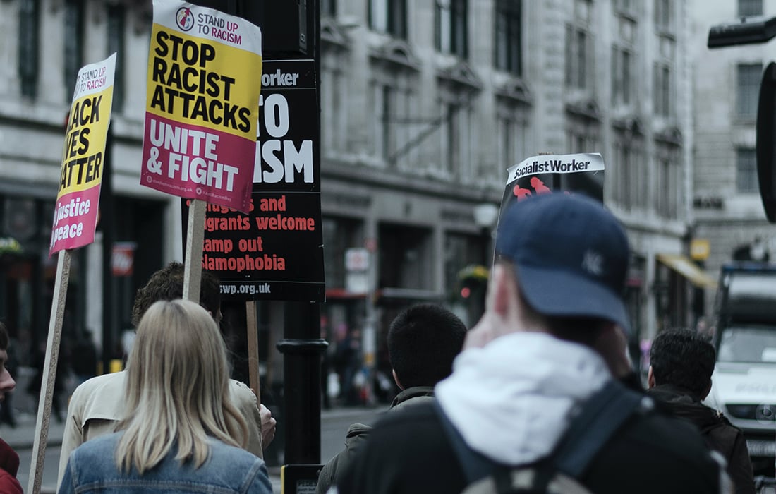 rear view of protestors on an anti racism march holding banners