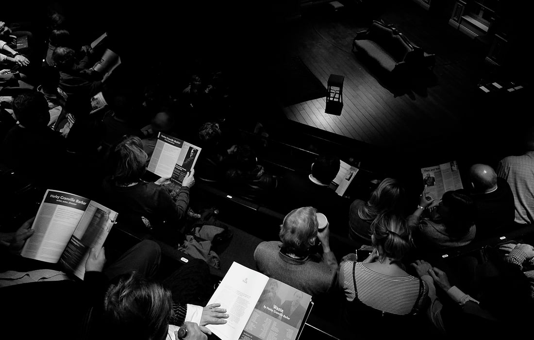 black and white aerial view of an audience by the side of the stage at The Almeida