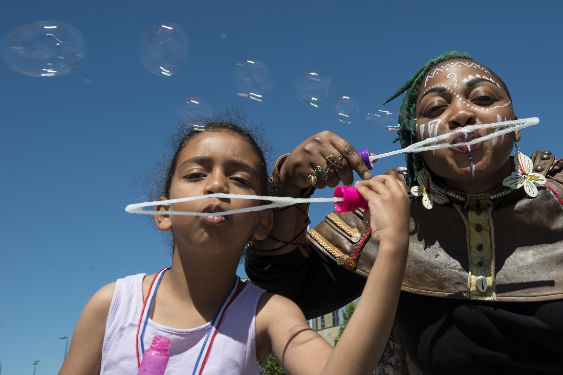 Two young people blowing bubbles into a camera