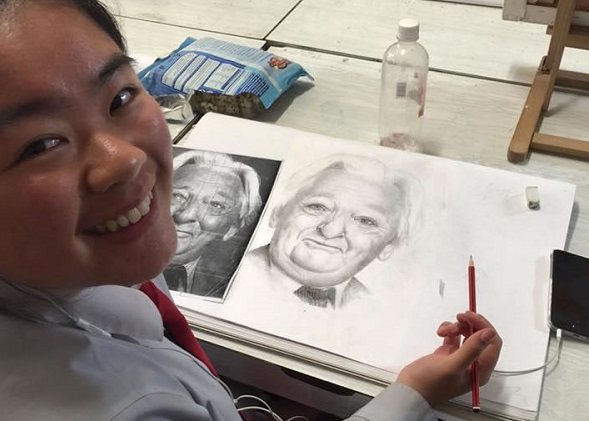 Girl doing a pencil sketch from a model