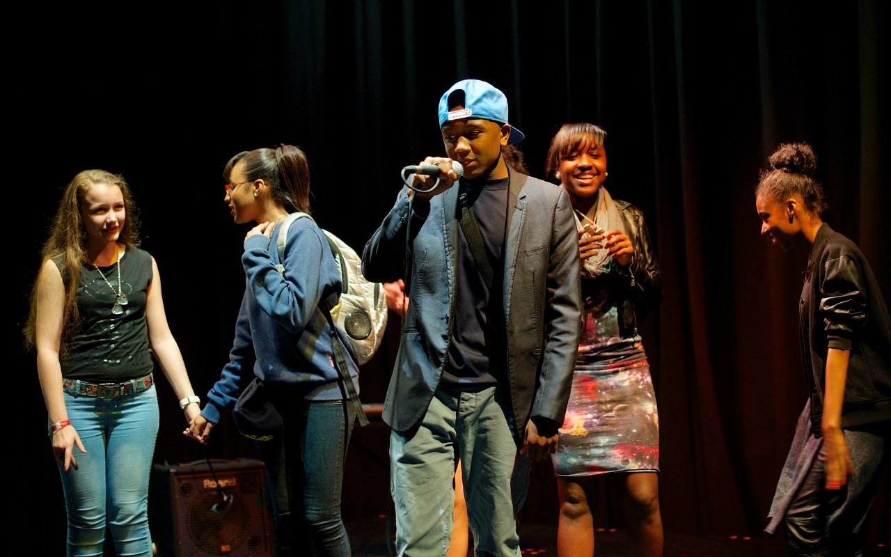 group of drama students perform on stage