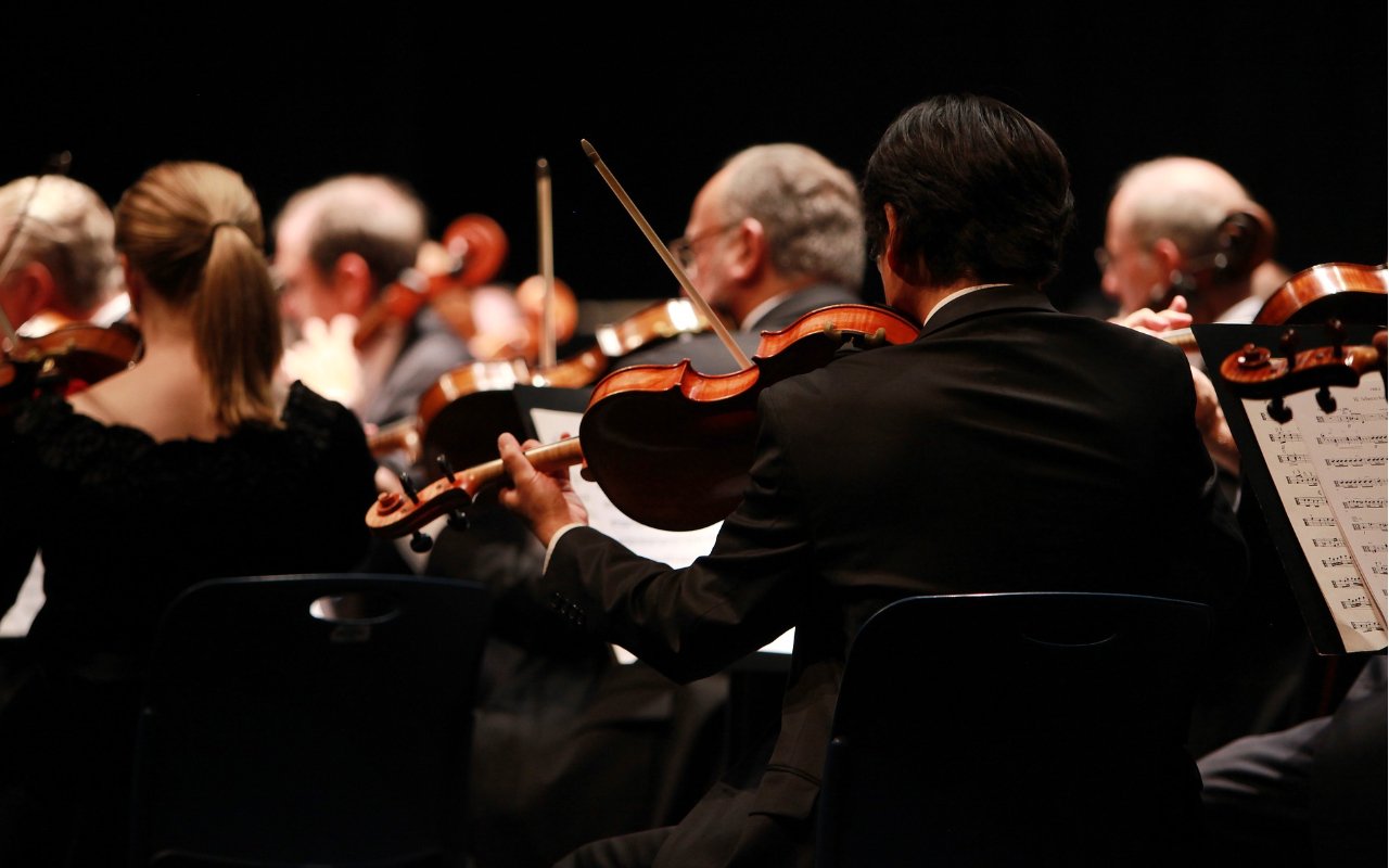 violinists play classical music in an orchestra