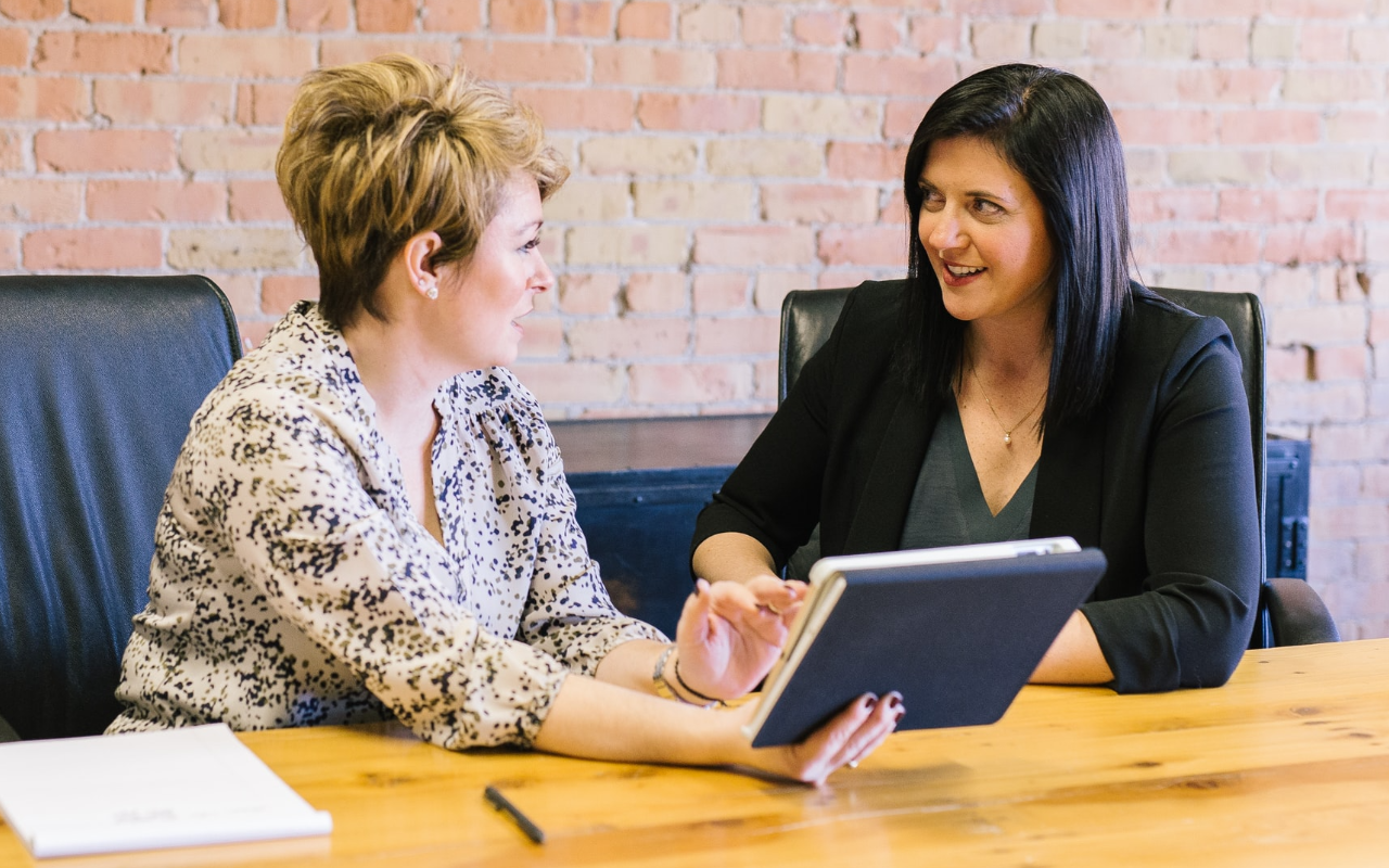 two women discuss their work