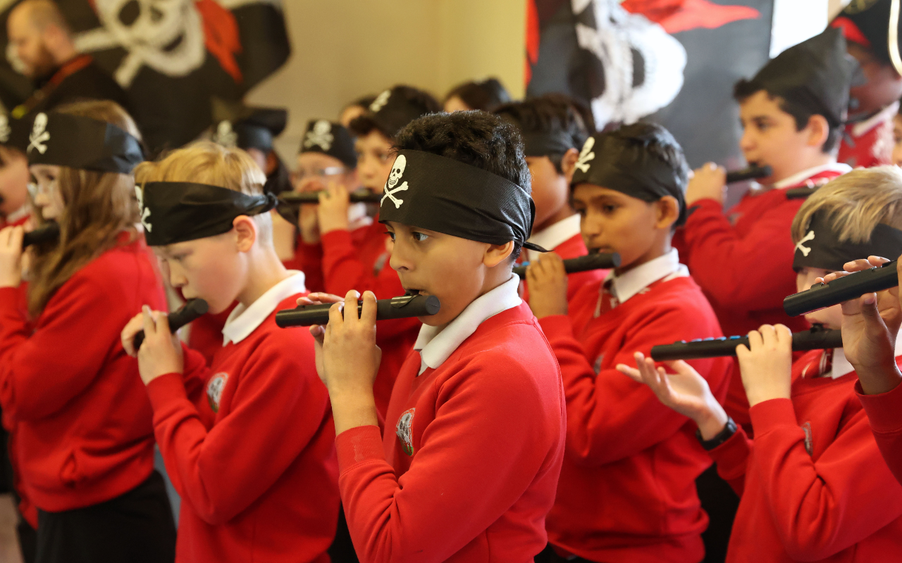 group of schoolchildren play musical instruments