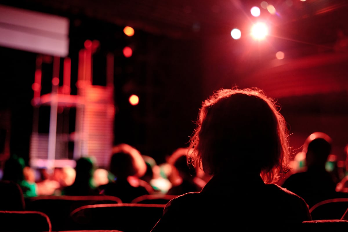 Silhouette of an audience member watching a piece of theatre