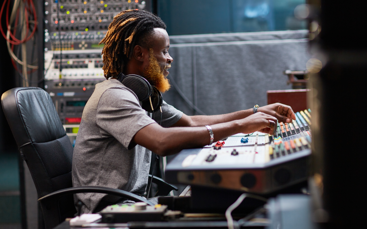 A young person sitting at a production desk