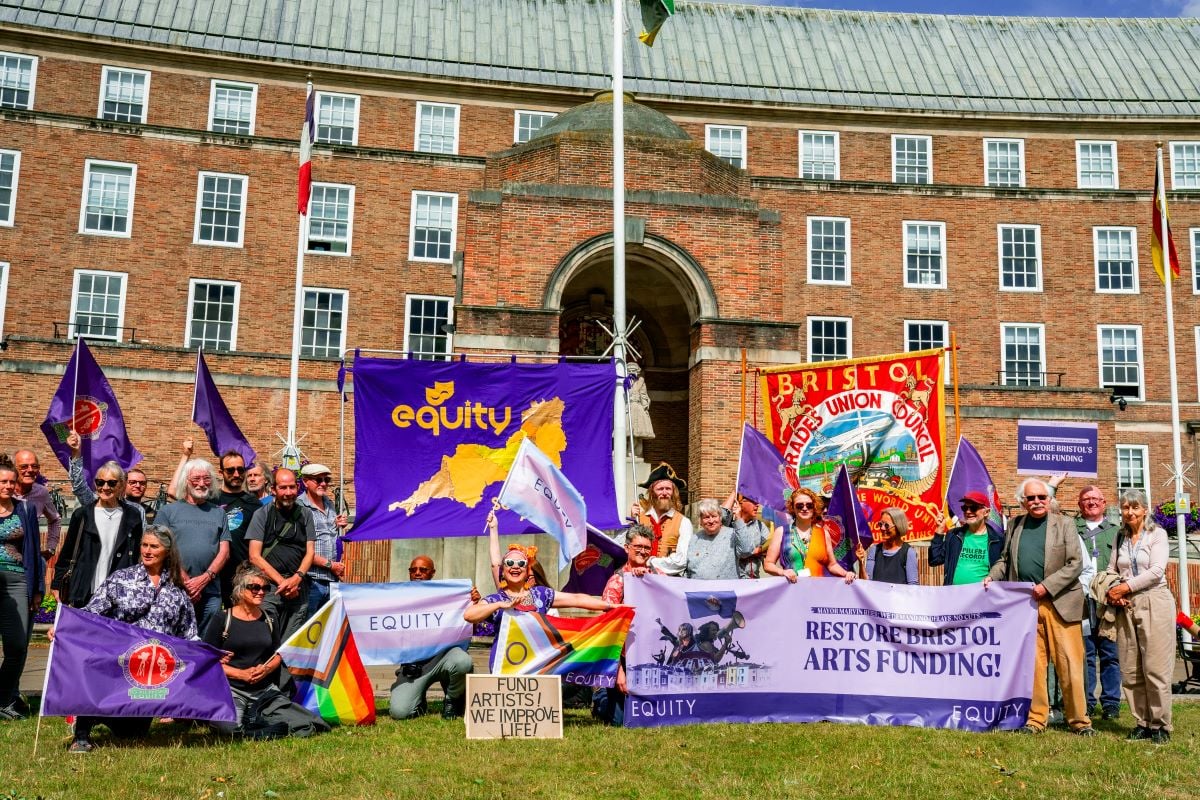 Creative workers gather outside city hall in protest with banners